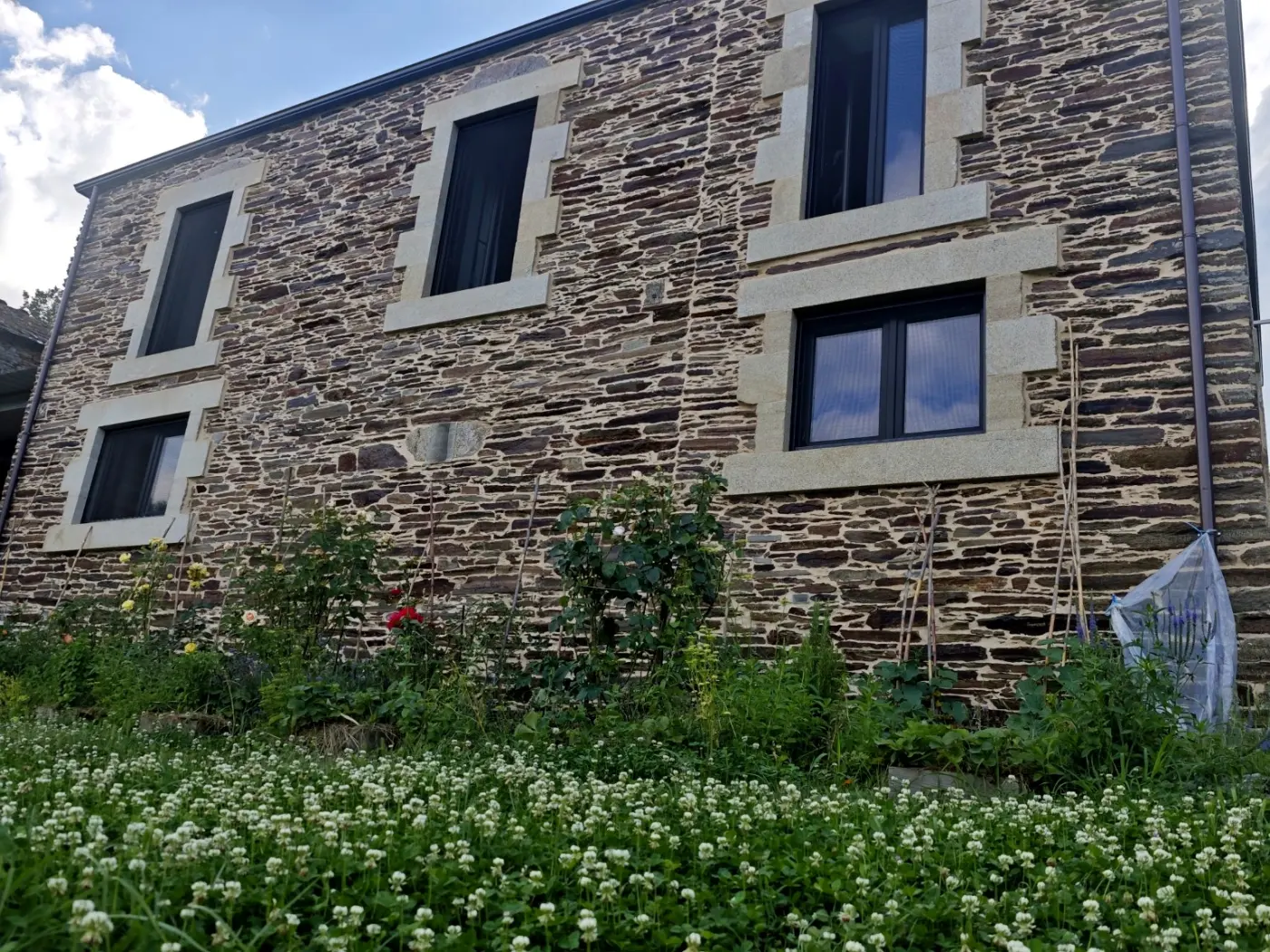 Granite and slate facade with the garden in flower