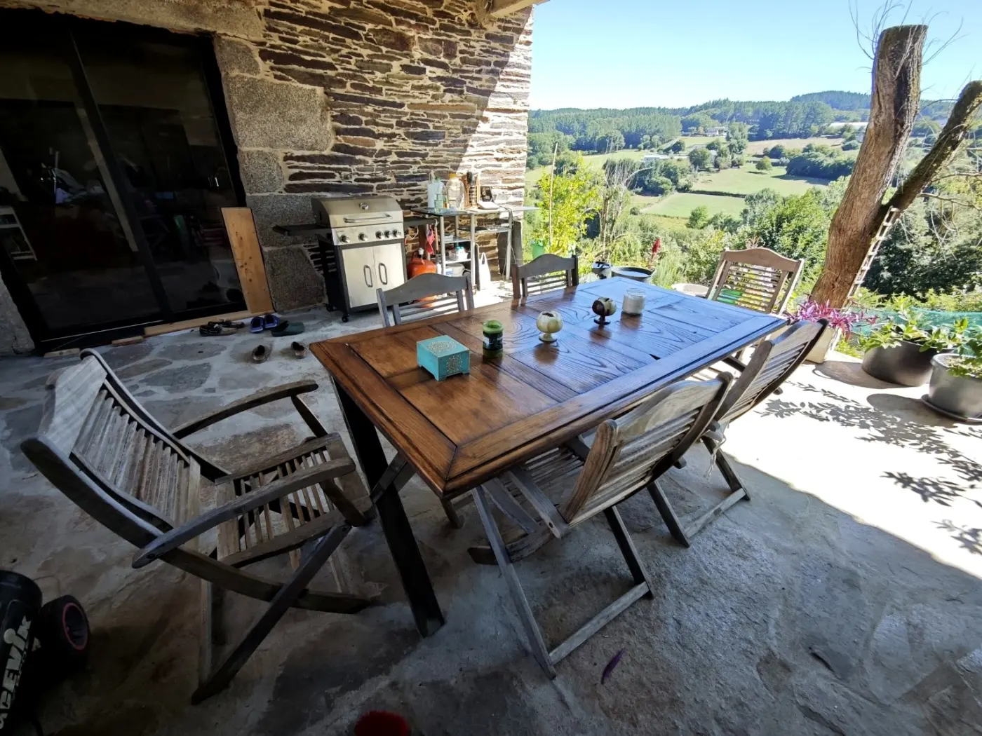 The patio with its dining table, looking over the valley