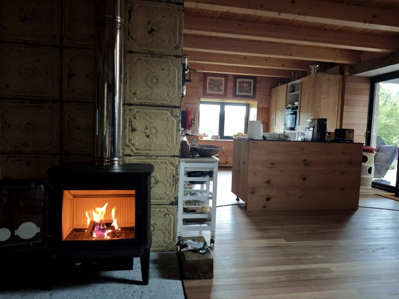 The cast-iron stove alight beside the kitchen
